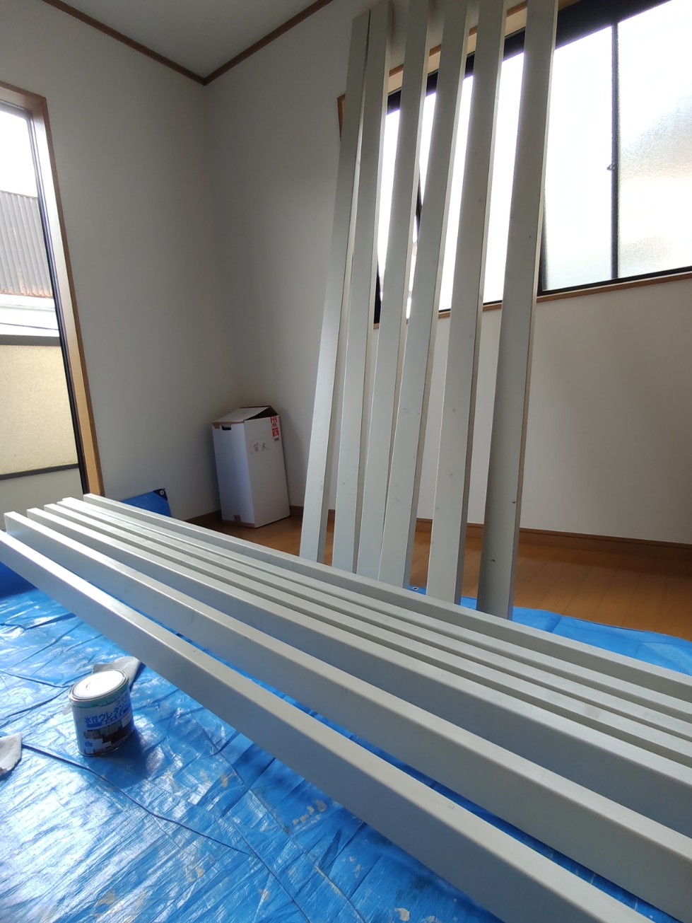 ブルーシート上で塗装作業する